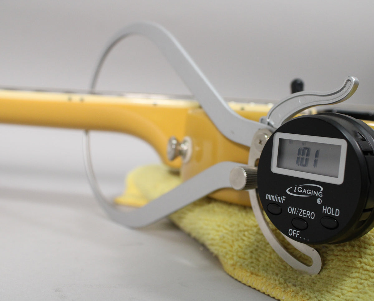 Close-up of the guitar's TV Yellow neck, with a digital caliper measuring the fret height at 1.01mm.