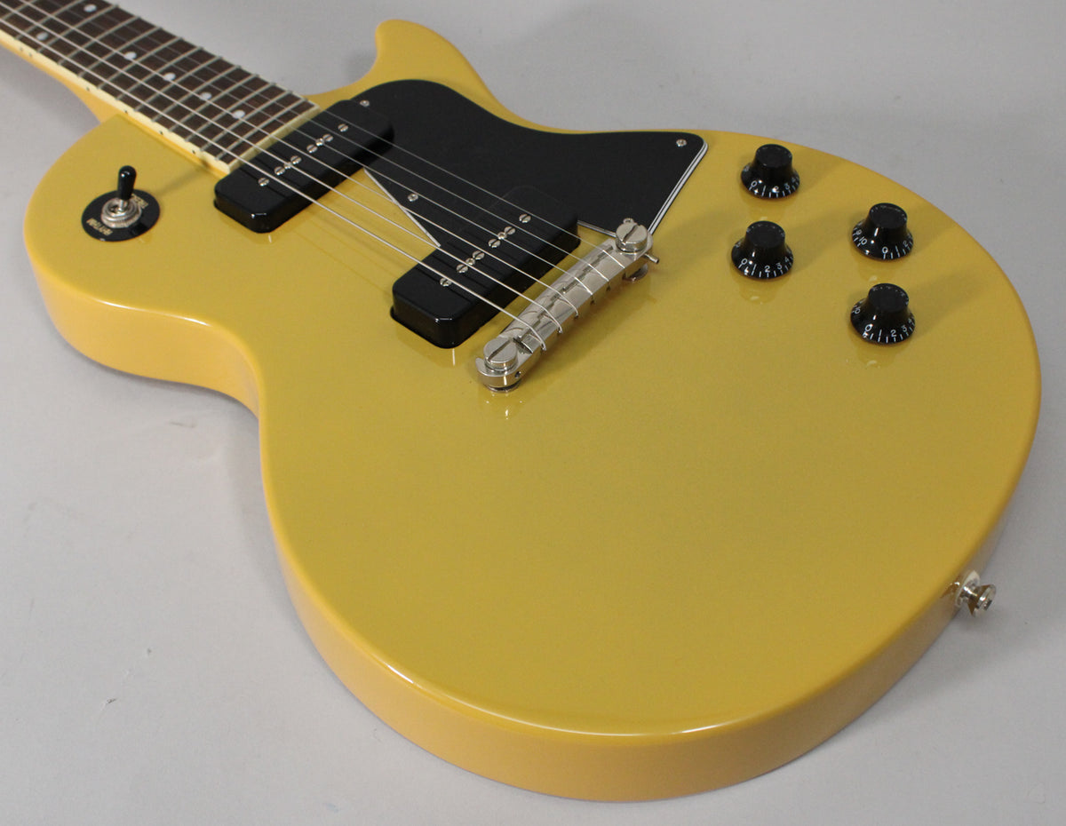 Close-up of a TV Yellow guitar body, showing two black P90 pickups, a black pickguard, and four black control knobs.