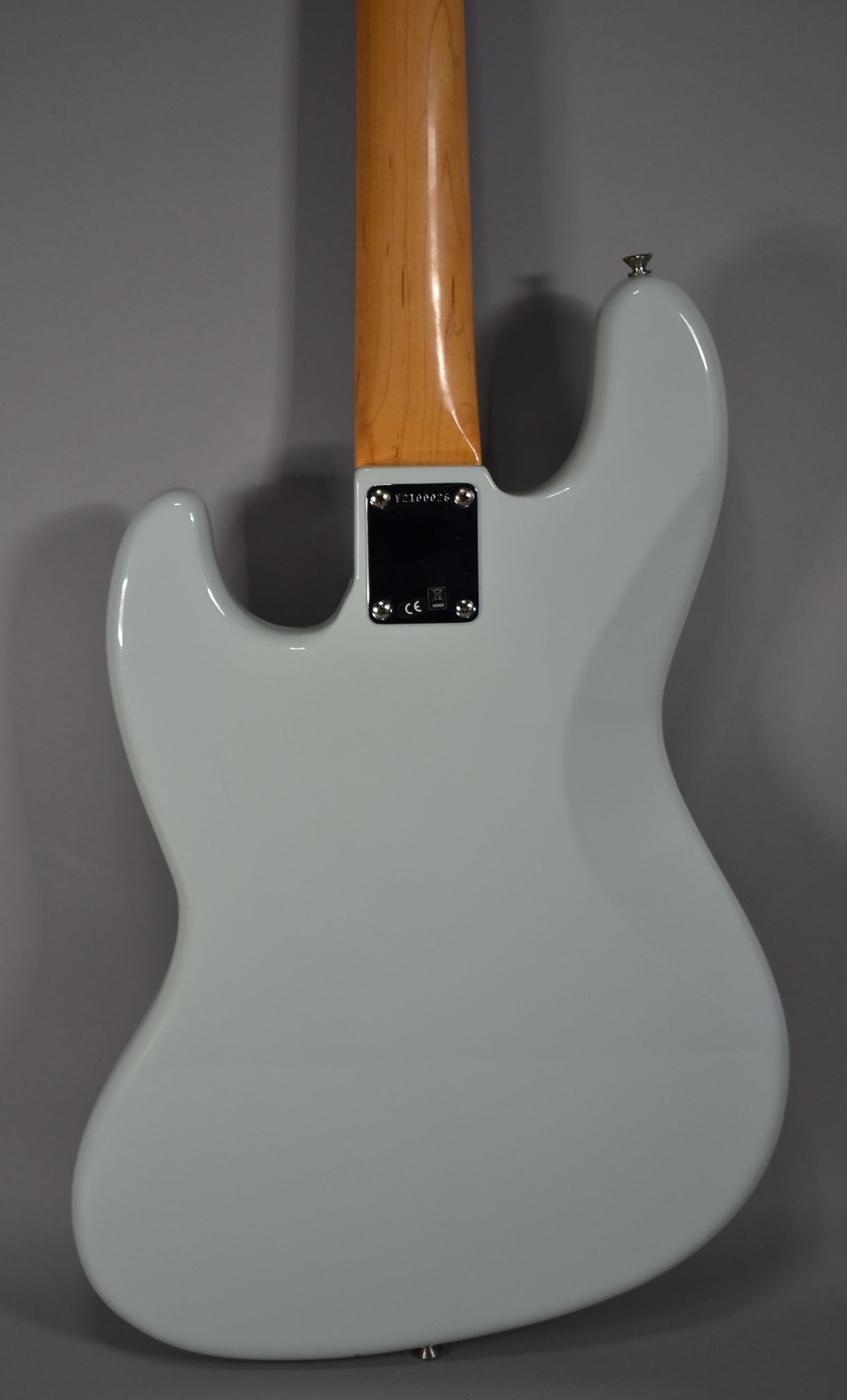 Rear view of a Sonic Blue Jazz Bass body with a maple neck, showing the neck plate and strap buttons.