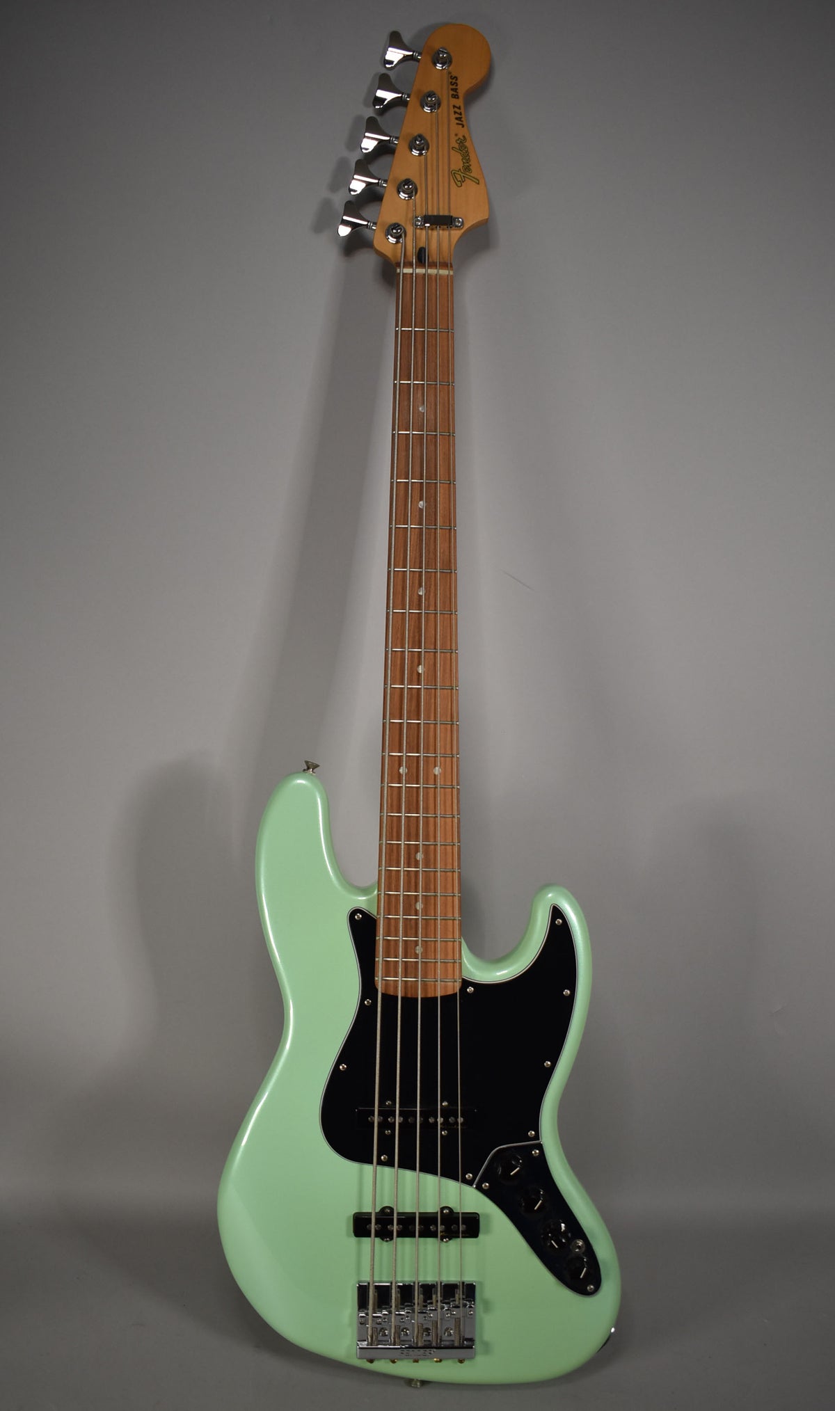 Full front view of a mint green 5-string bass with a black pickguard, chrome hardware, and a light brown fretboard.