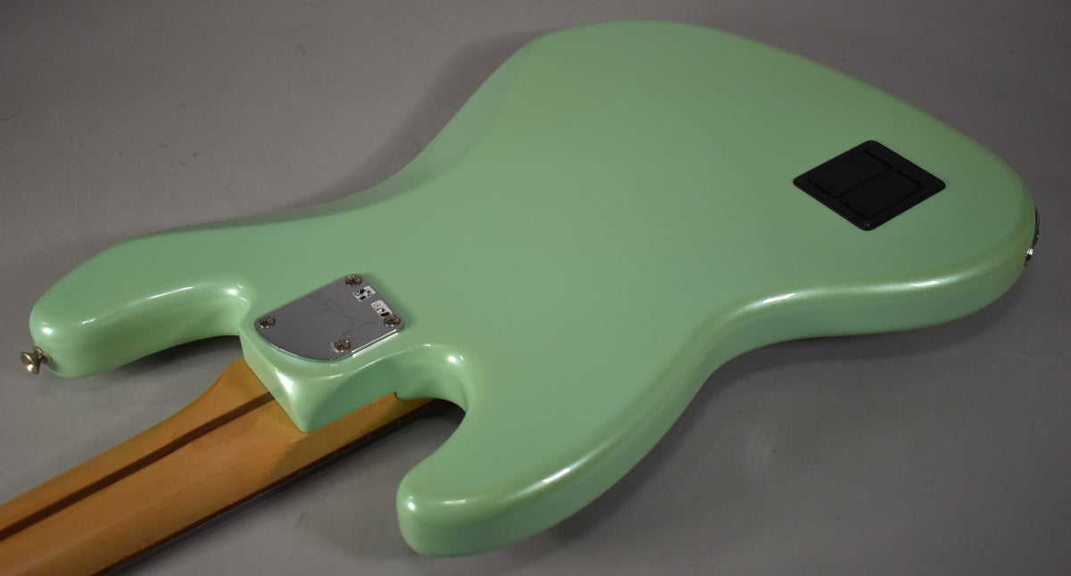 The back of a glossy Surf Pearl bass, showing the neck joint, strap button, and a black rectangular battery compartment.