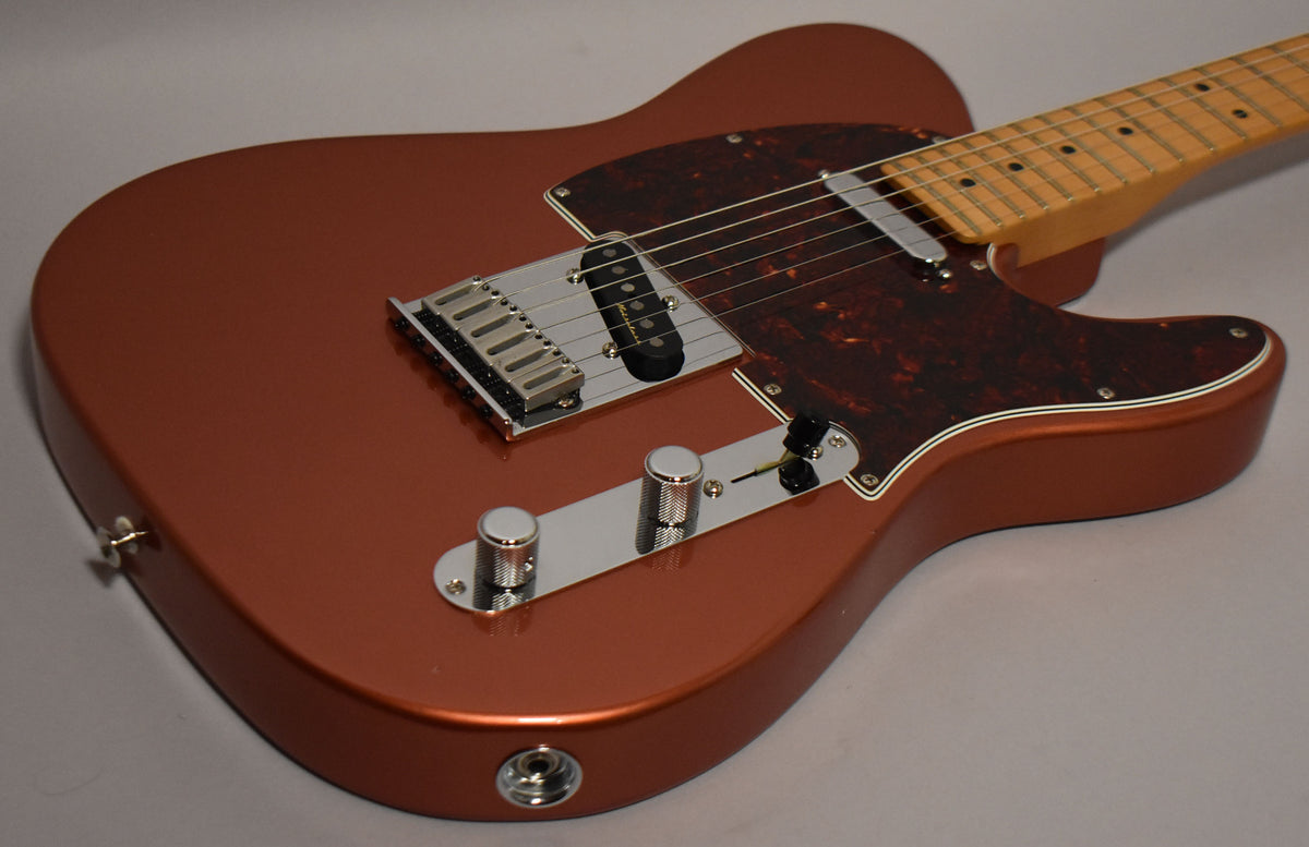 A candy apple red Telecaster body with a tortoiseshell pickguard, chrome bridge, control plate, and knurled knobs.