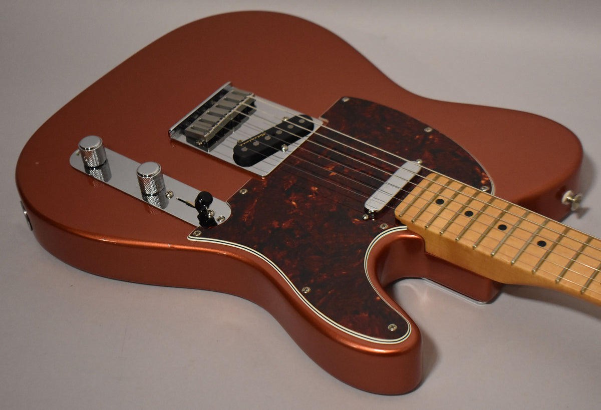 Candy Apple Red Telecaster body, angled from above, showing the tortoiseshell pickguard, chrome control plate, and maple fretboard.