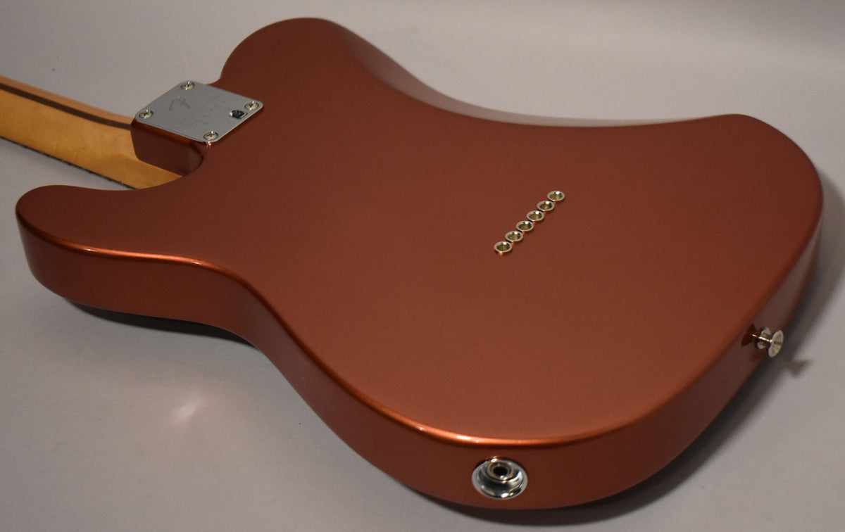 The guitar's metallic red back shows a chrome neck plate, six gold string ferrules, and a chrome output jack.