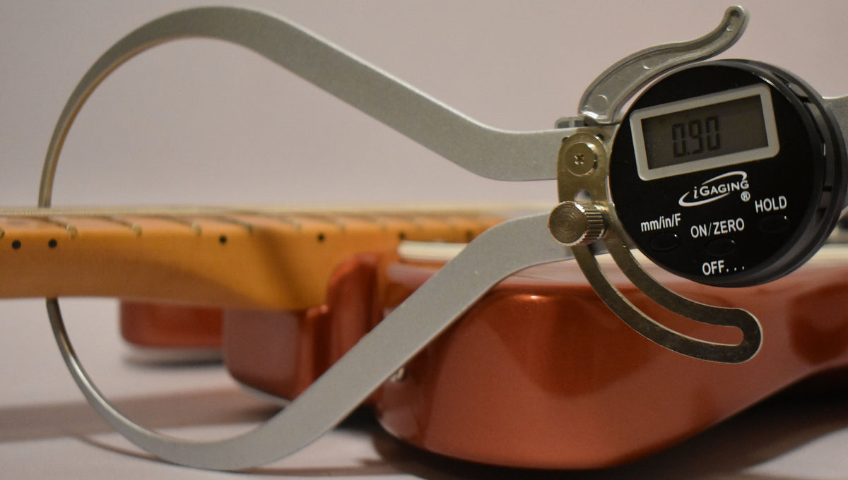 A digital caliper measures the neck relief at 0.90mm on the Candy Apple Red Telecaster's maple fretboard.
