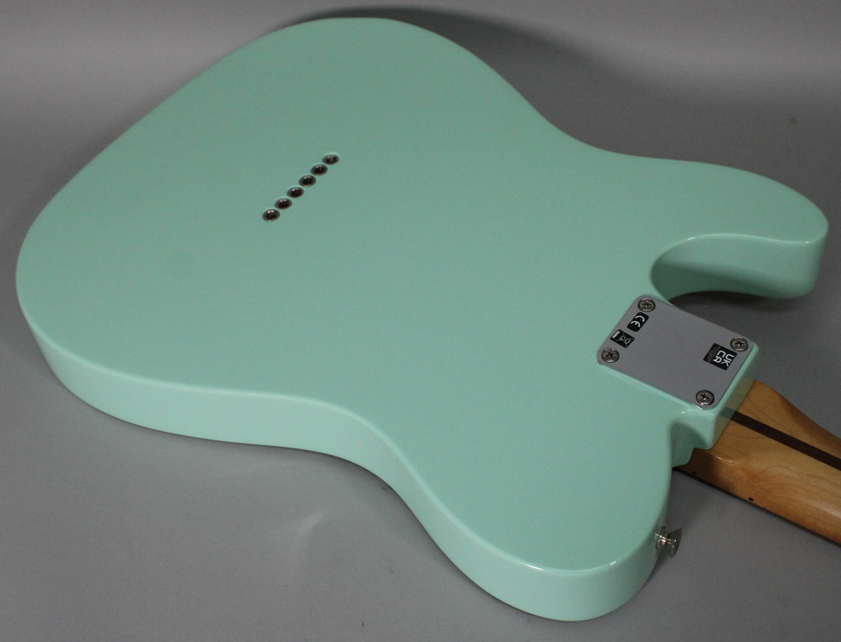 The back of a Surf Green Telecaster body, showing the string-through-body ferrules, neck plate, and a strap button.