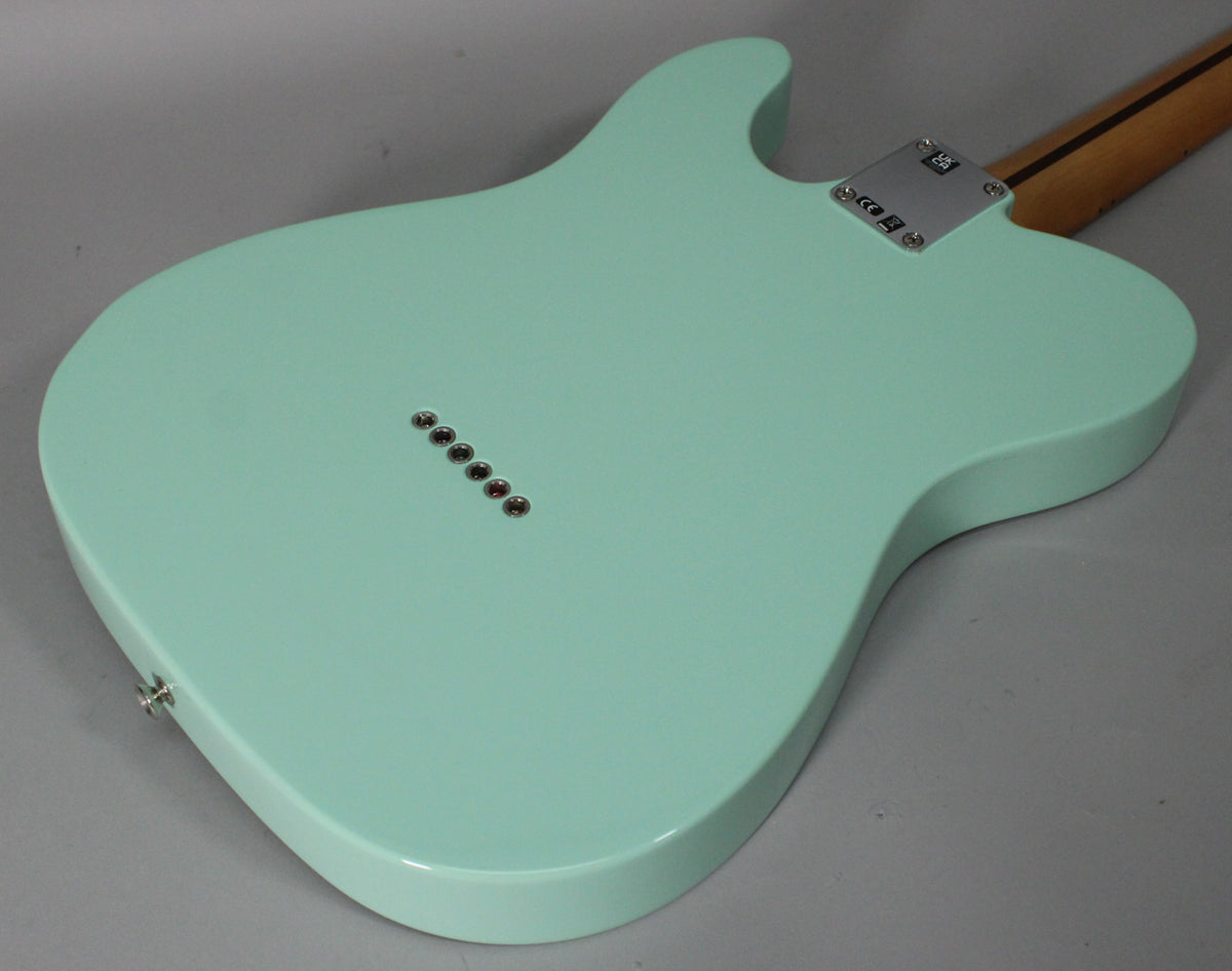 The back of a surf green Telecaster body, showing the string-through ferrules, neck plate, and strap button.