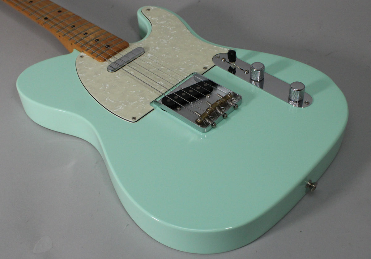 Surf green Telecaster body, angled from the lower bout, showing a pearloid pickguard, chrome bridge, and control plate.