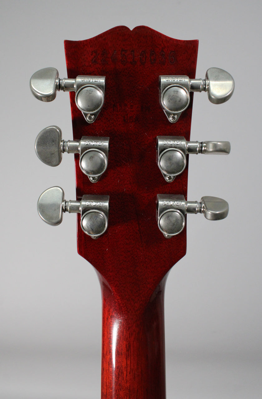 The back of a deep red headstock and neck, showing six brushed nickel tuners with kidney-shaped buttons.