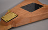 Close-up of the guitar's natural wood back, showing the gold neck plate and strap button, and a black control cavity cover.