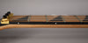 Close-up of the guitar neck from the side, showing the light wood neck, dark fretboard with triangular inlays, and gold locking nut.