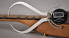 A digital caliper measures the string height above the fretboard, showing "0.89" on its display.