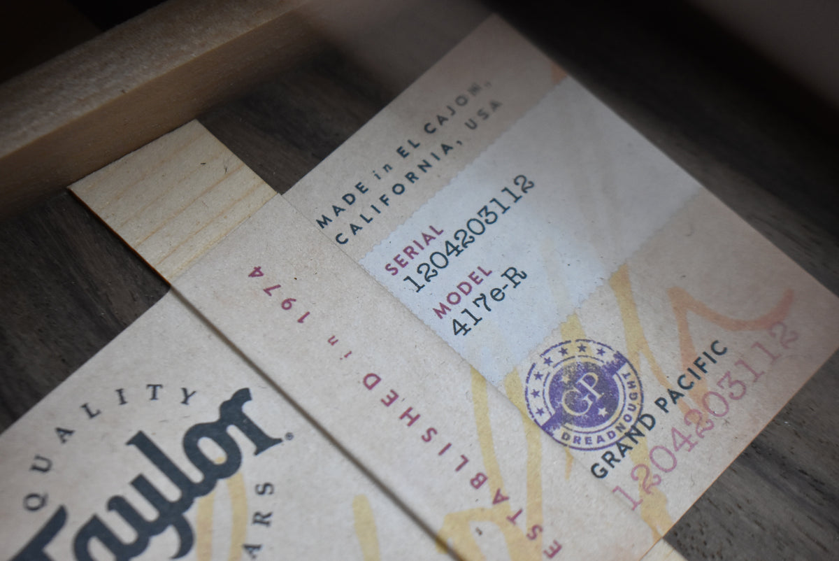 Close-up of the guitar's paperwork, showing a serial number, model number, and a purple "GP Dreadnought" stamp.