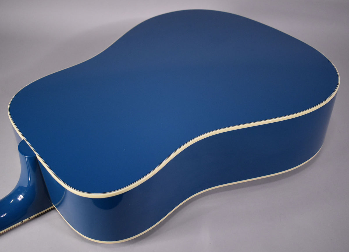 The Big Sky Blue acoustic guitar's back and sides are visible, with cream binding along the edges and a glossy finish.