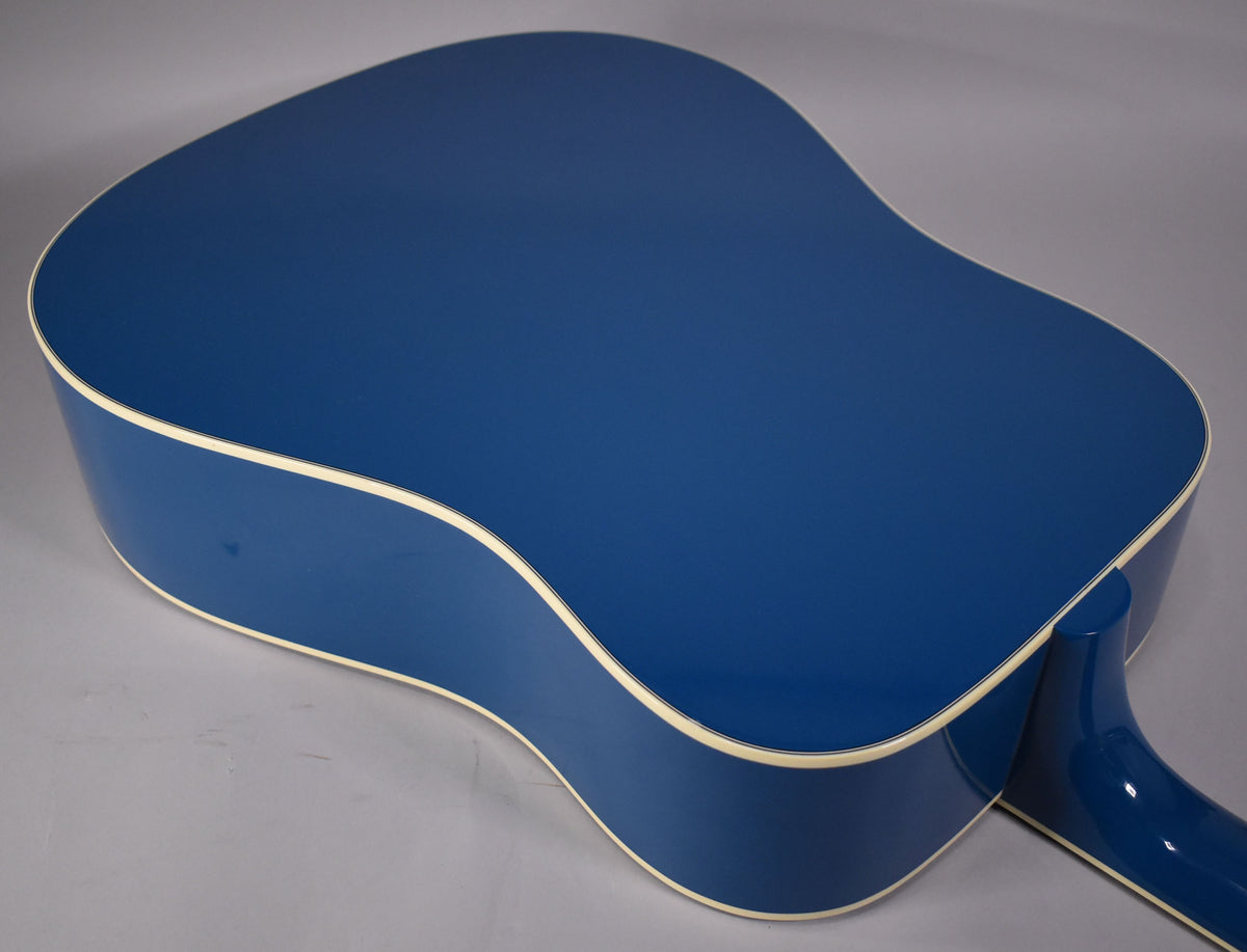 The back of the Big Sky Blue acoustic guitar, showing its glossy finish, cream binding, and part of the neck.