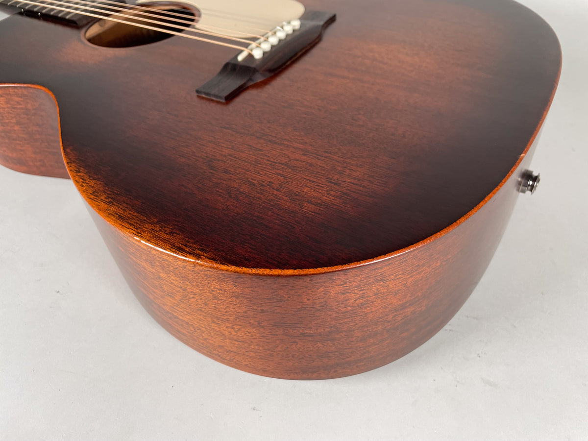 Close-up of the dark brown acoustic guitar's lower bout, showing the satin top, gloss sides, and endpin jack.