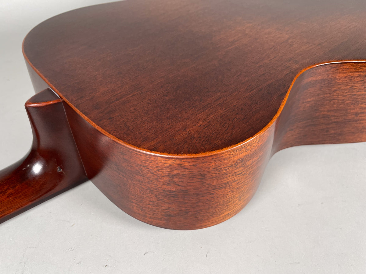 Close-up of the guitar's dark brown satin body and neck heel, showing the lower bout and waist from the back.
