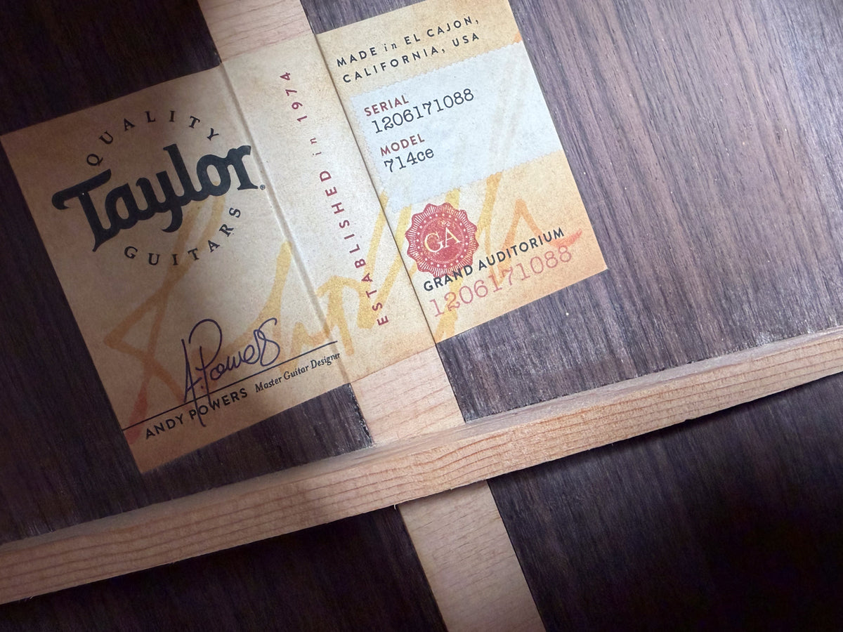 Close-up of the guitar's interior label, showing model and serial numbers, with light wood bracing and dark wood grain visible.