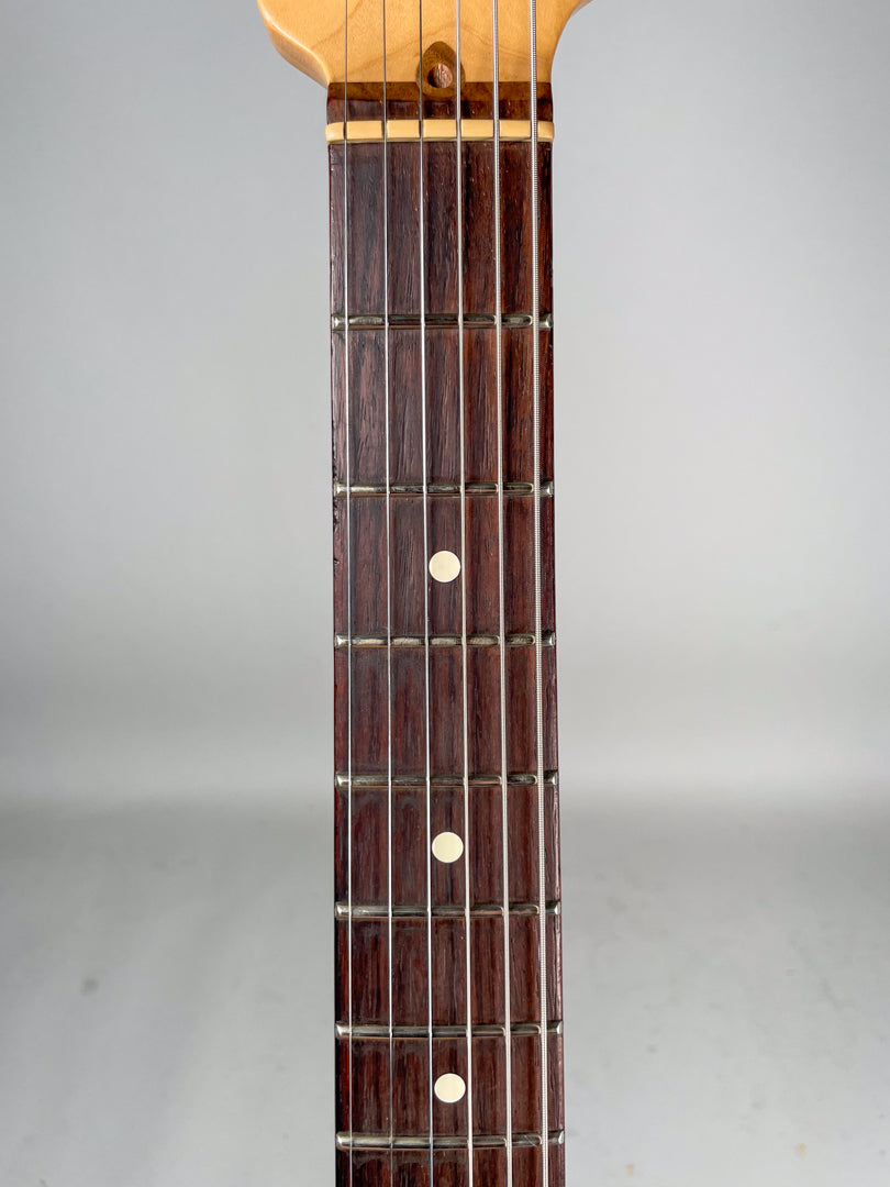 The guitar's dark rosewood fretboard with white dot inlays and light maple neck are shown from the 1st to 7th fret.