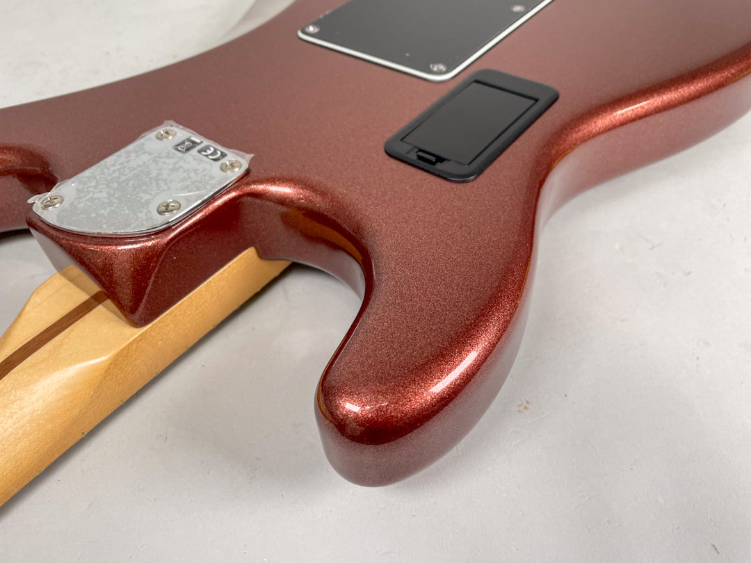 Close-up of the guitar's classic copper metallic finish body from the back, showing the neck plate and a black battery compartment.