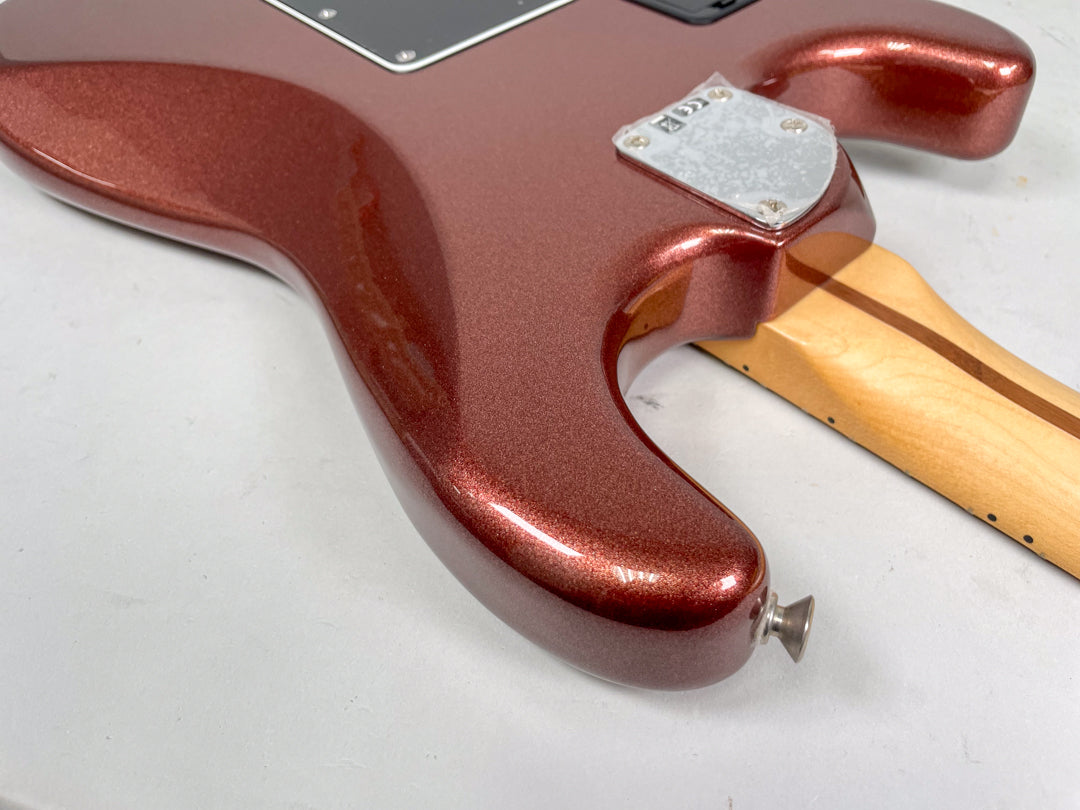 The guitar's lower bout and neck heel, showing the metallic copper finish, chrome neck plate, and a strap button.