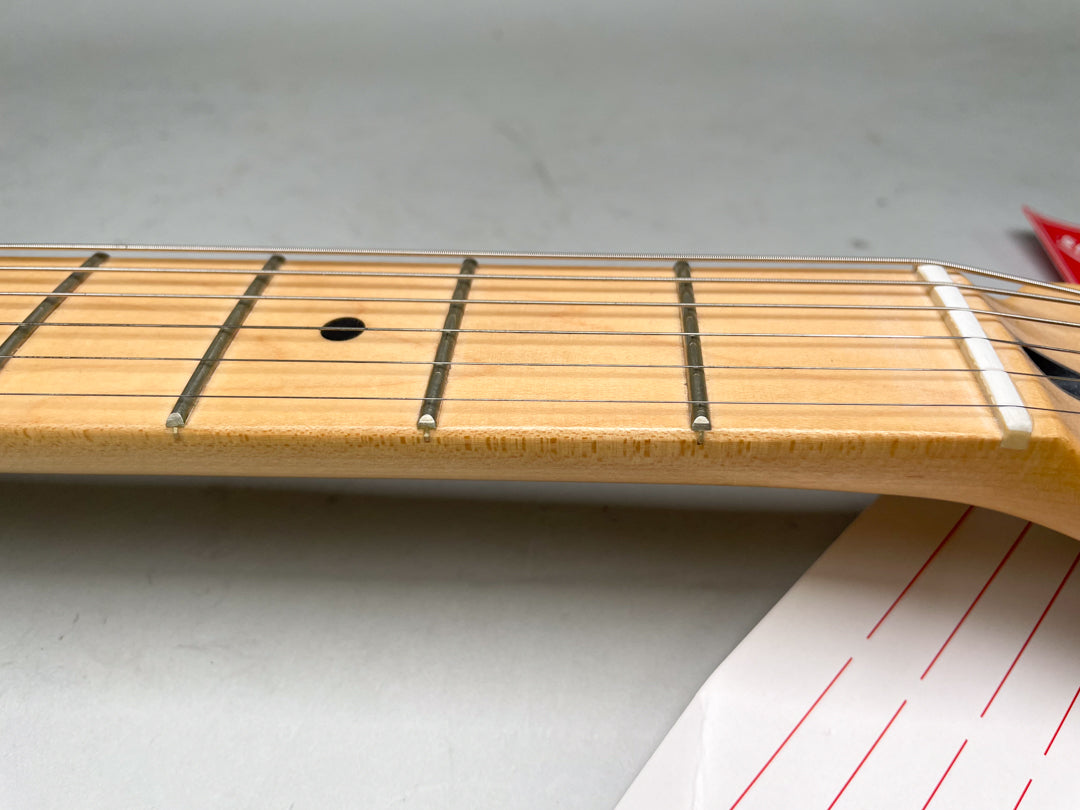 Close-up of the maple fretboard and frets, showing a black dot inlay at the 7th fret and a white nut.