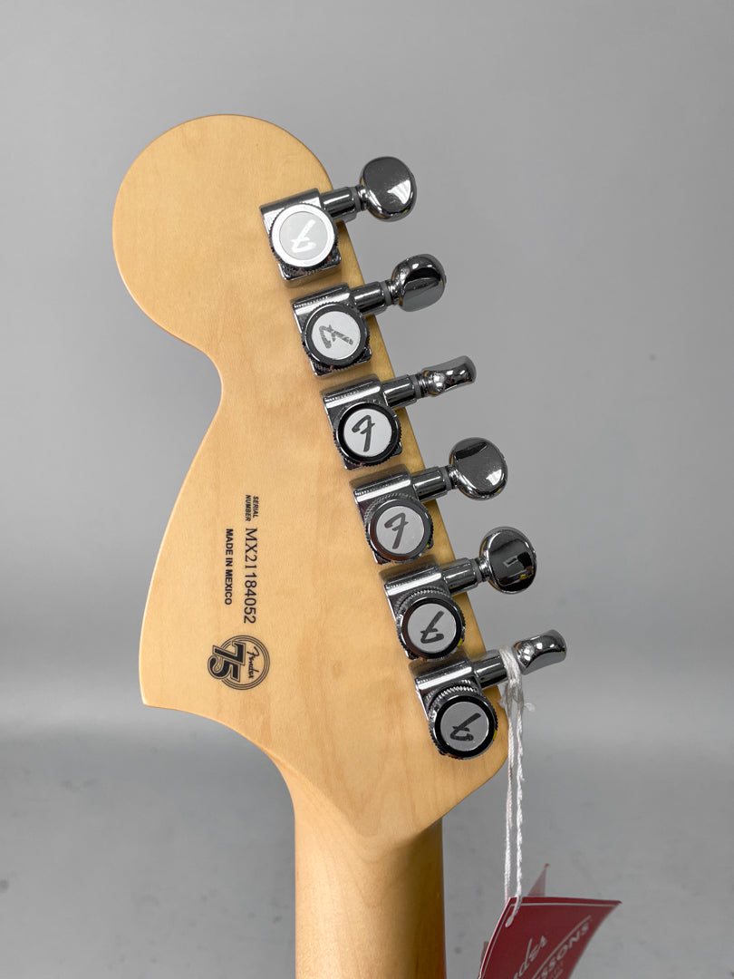 The back of the guitar's headstock, light wood with a satin finish, shows six chrome tuners and a red hang tag.