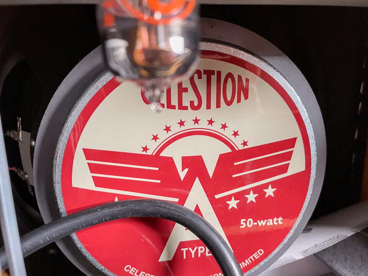 Close-up of the speaker's red and cream label, showing "50-watt" and a tube glowing above it.