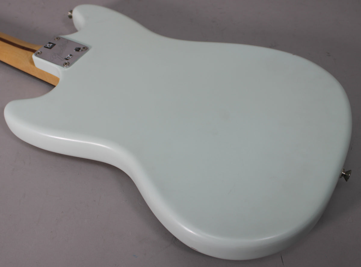 The back of a light blue electric guitar, showing the neck plate and a strap button, with a few minor scuffs.