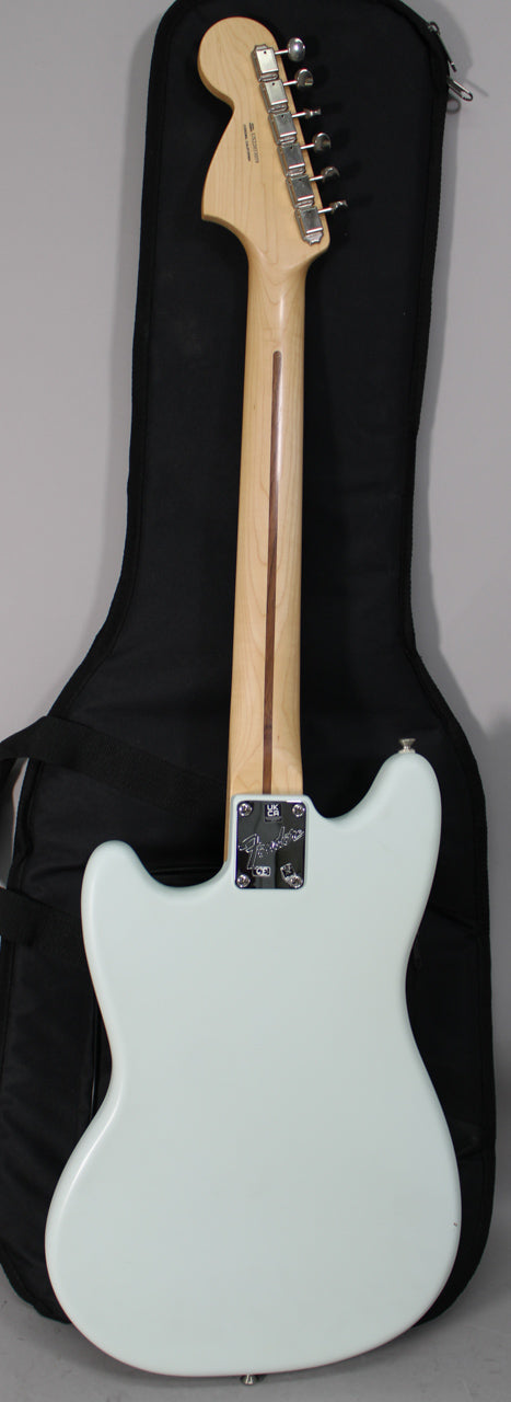 The back of a light blue electric guitar with a light wood neck, chrome tuners, and a neck plate.
