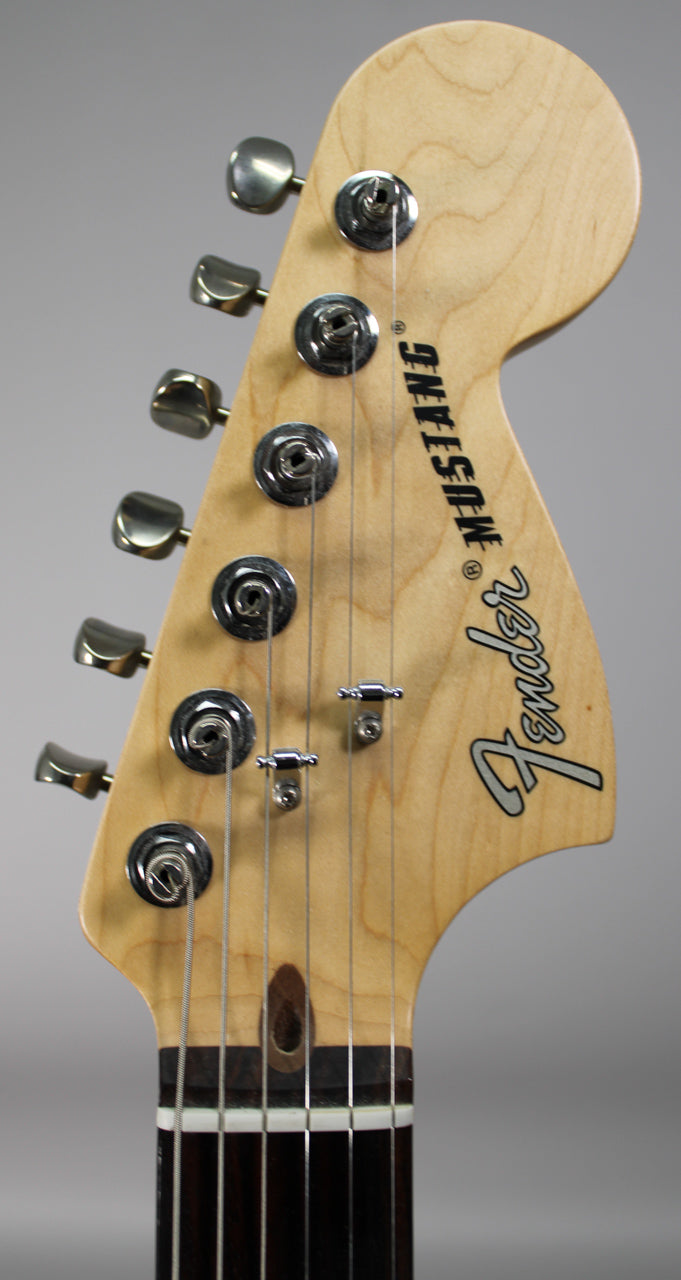 Close-up of the natural maple headstock with six brushed chrome tuners, two string trees, and a dark rosewood fretboard.