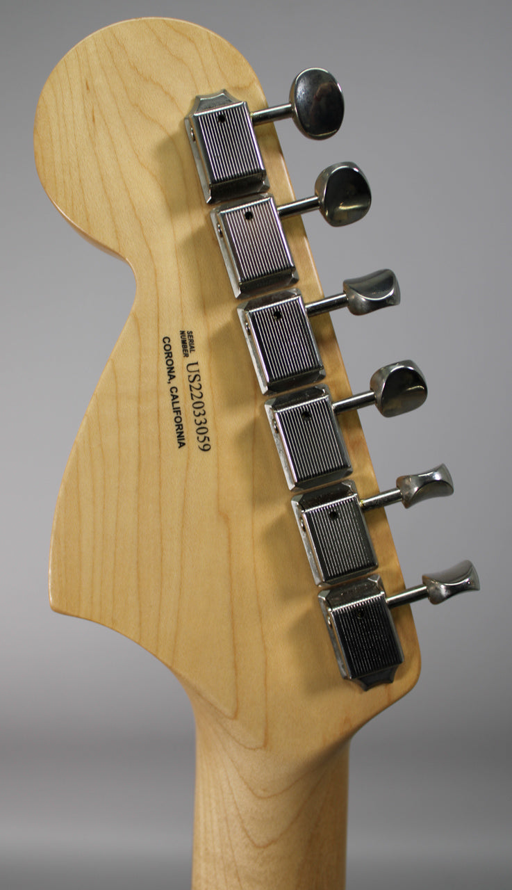 The back of a light maple headstock and neck, with six chrome tuners featuring ribbed rectangular housings and oval buttons.