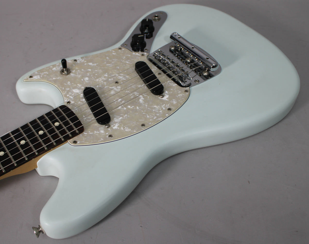 Light blue electric guitar body, angled from above, showing a pearloid pickguard, two black single-coil pickups, and chrome hardware.