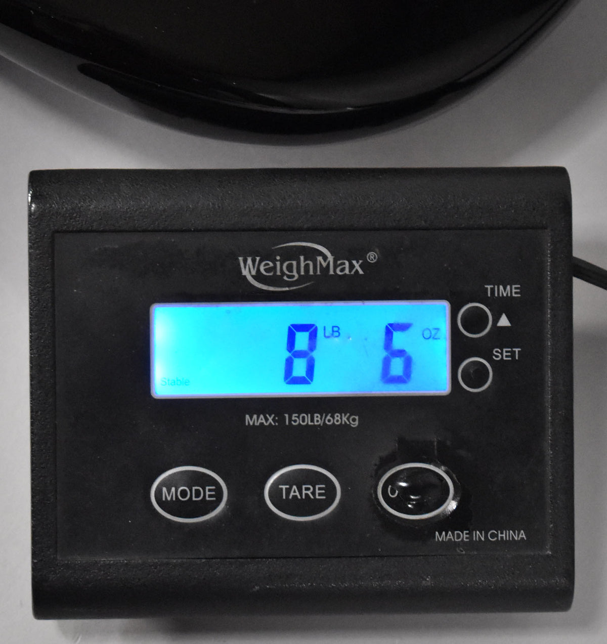 The guitar's sunburst body rests on a black digital scale, displaying "8 LB 6 OZ" in bright blue numbers.
