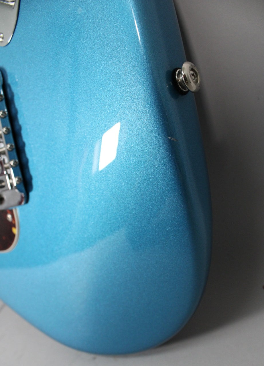 Close-up of the guitar's lower bout in metallic Lake Placid Blue, showing a chrome strap button and a small scratch near it.