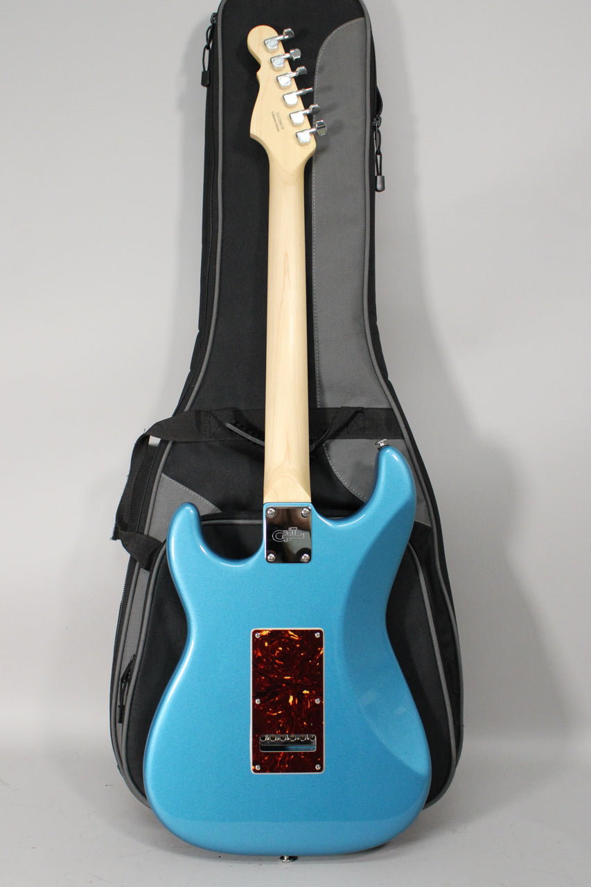 Rear view of a metallic blue electric guitar with a light wood neck, chrome tuners, and a tortoiseshell tremolo cover.
