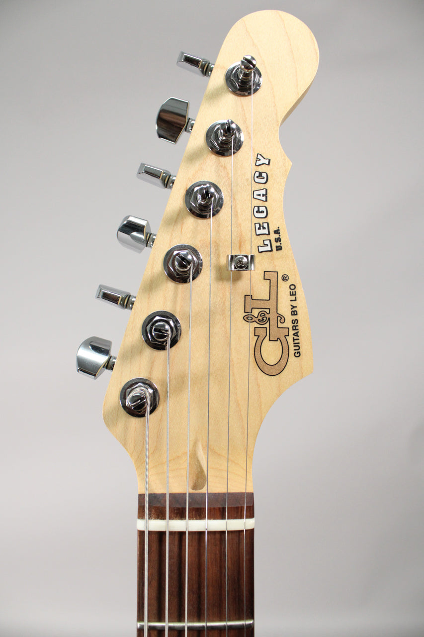 Close-up of the guitar's light maple headstock with six chrome tuners, showing the dark fretboard and white nut.