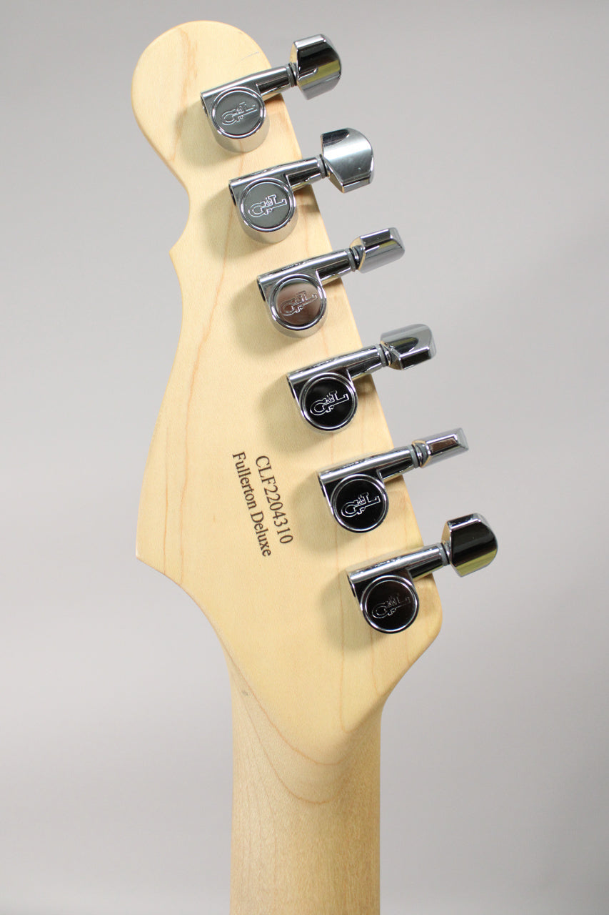 The back of a light wood headstock with six chrome tuning machines, angled to show the top three.