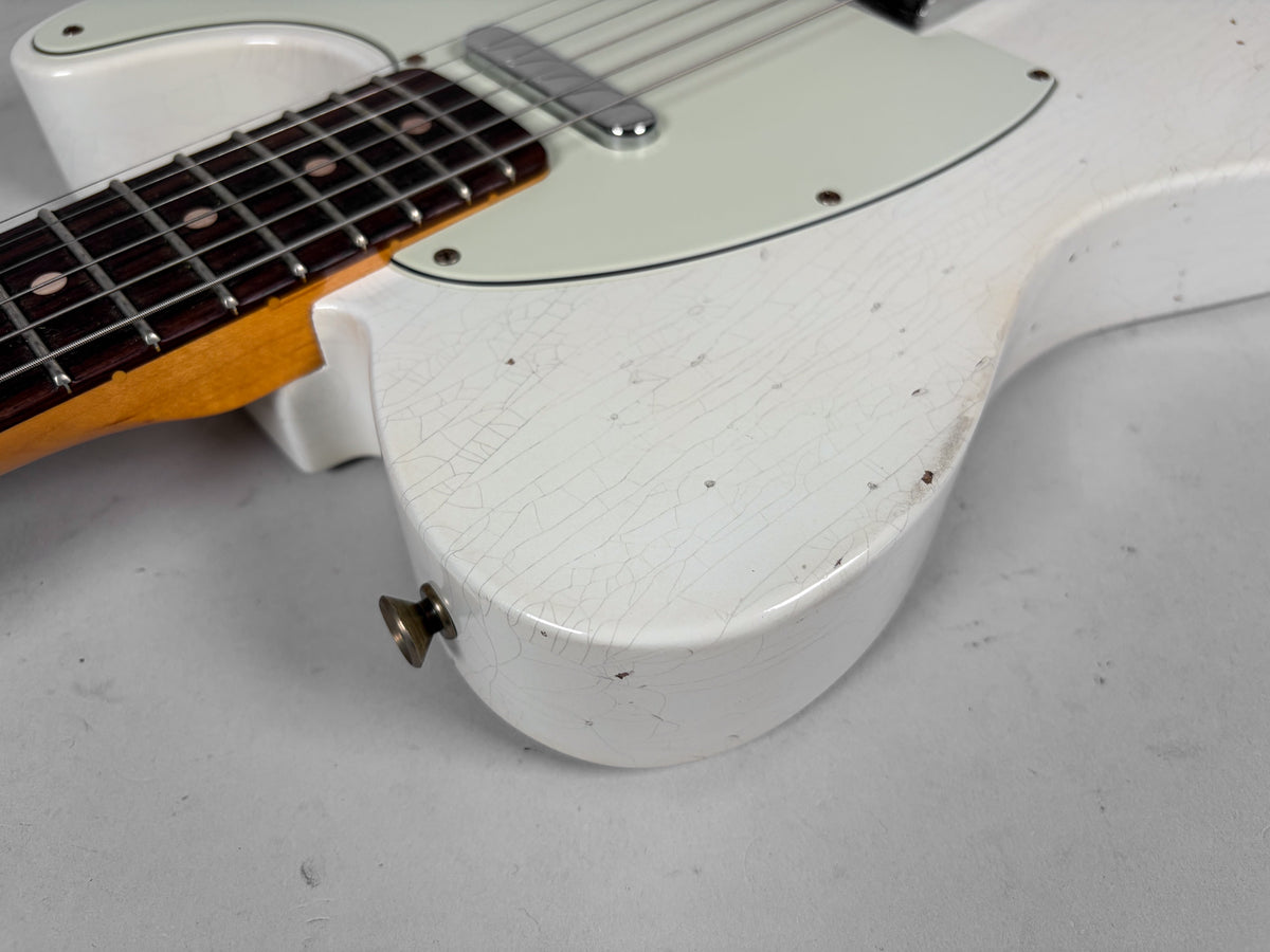 Close-up of the Olympic White body, showing extensive finish checking, chips, and a dark rosewood fretboard with dot inlays.