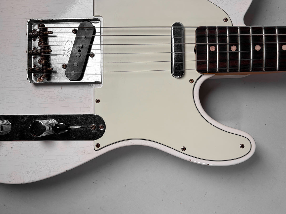 Close-up of the Olympic White body with heavy finish checking, showing the bridge, neck pickup, control plate, and pickguard.