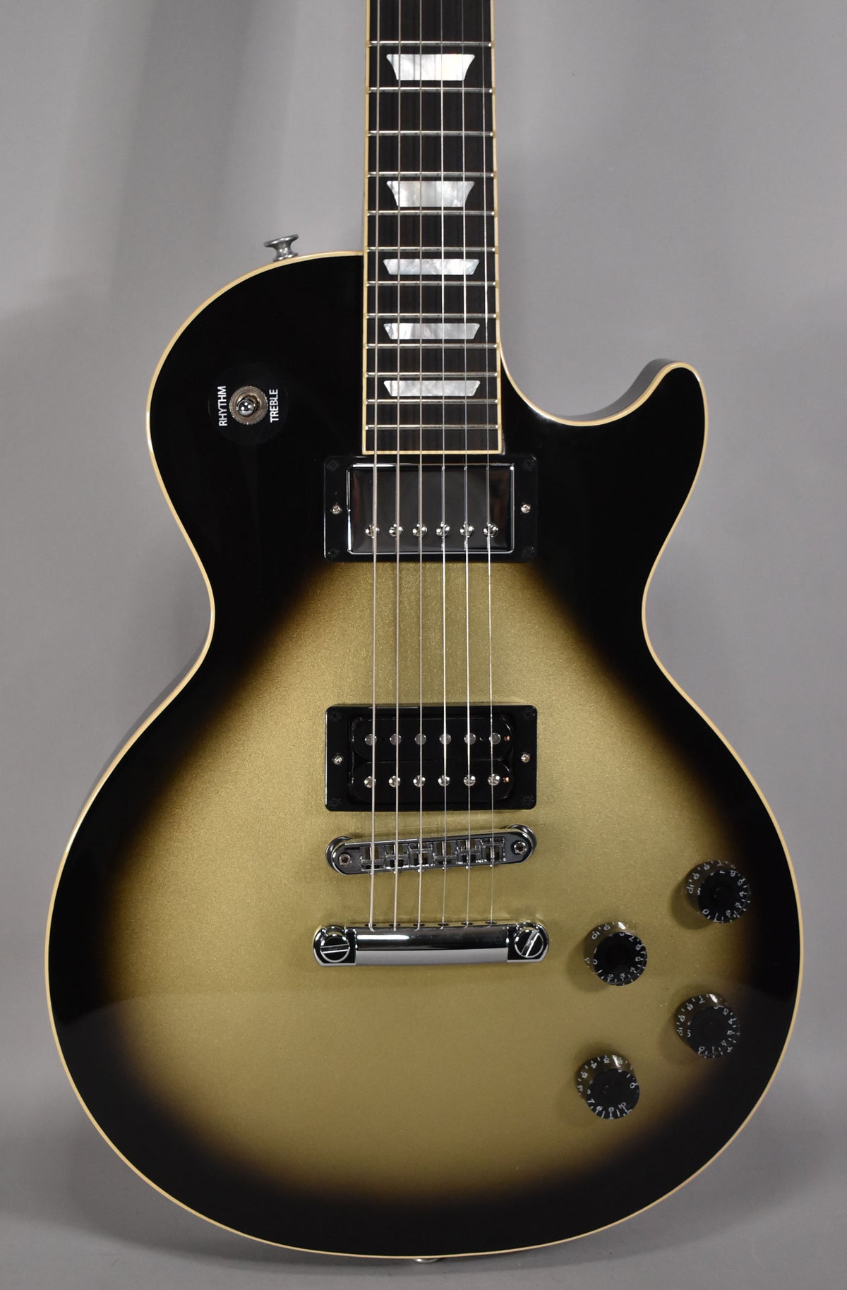A gold and black Les Paul guitar with a cream binding, two humbuckers, and four black control knobs.