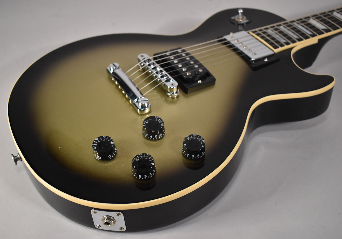 The guitar's body, angled from above, shows a silverburst finish, black pickup, chrome bridge, and four black numbered control knobs.