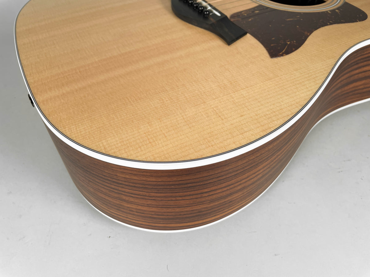 Upper bout of a natural finish acoustic guitar with light wood top and dark wood sides, framed from above.