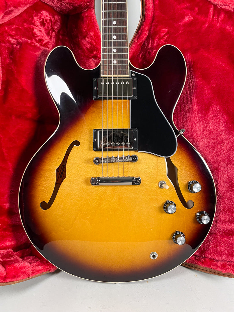 Full view of a glossy sunburst semi-hollowbody electric guitar with chrome hardware, black pickguard, and four black-capped knobs.
