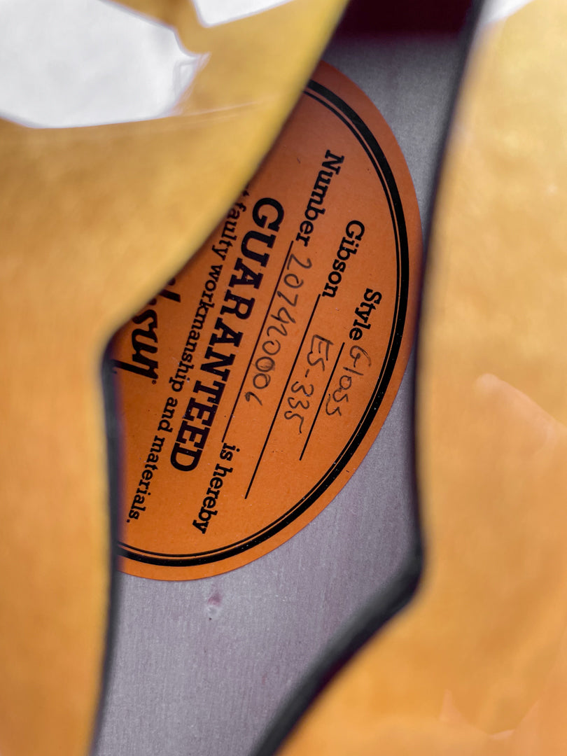 Close-up of the guitar's orange internal label, showing "Style: Gloss" and "ES-335" handwritten, with a serial number.