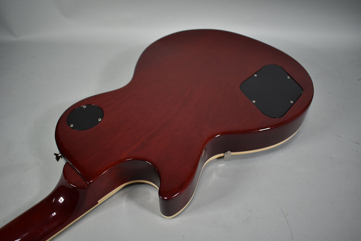 The guitar's dark cherry sunburst back and neck are shown from above, revealing two black control cavity covers and cream binding.