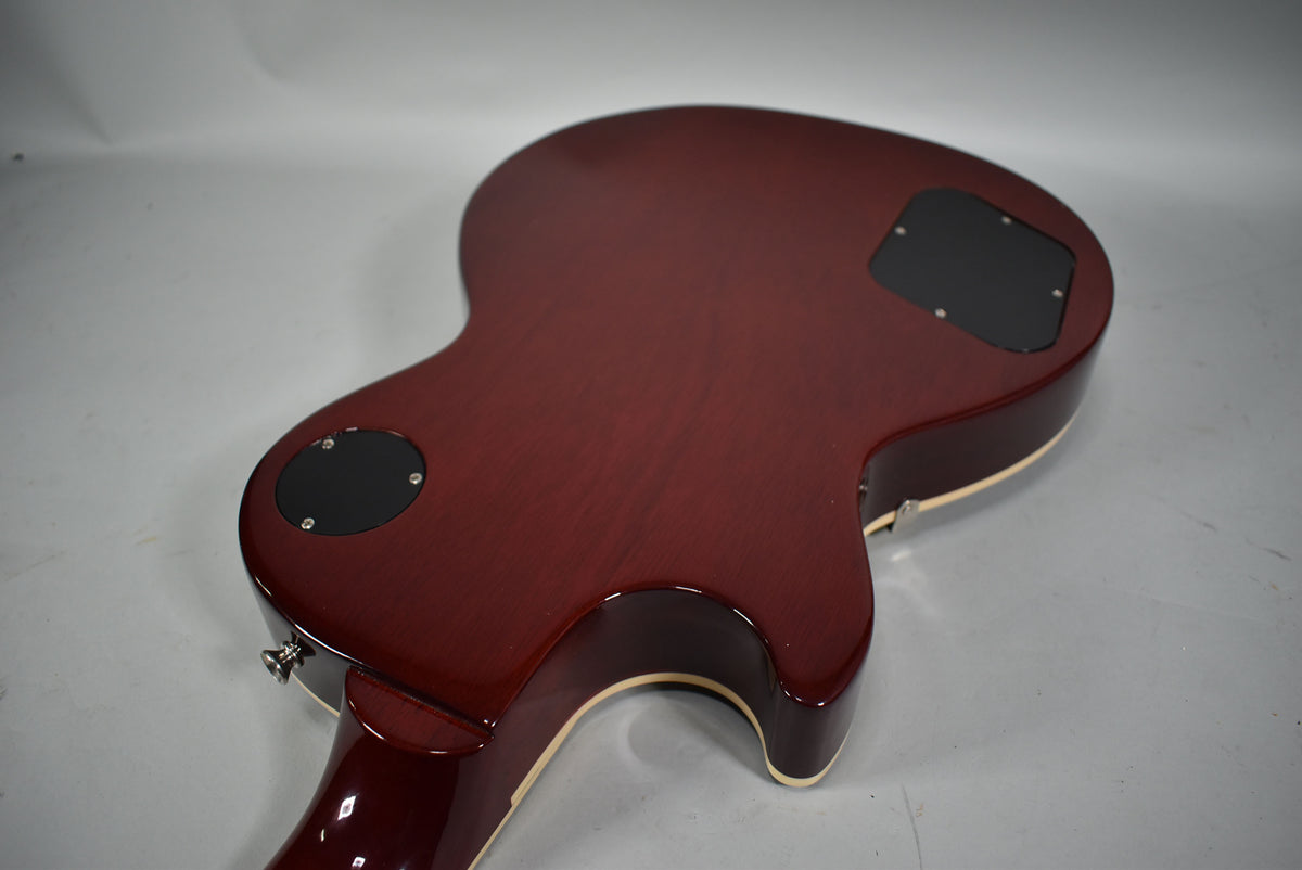 The guitar's back, in a dark cherry sunburst, shows two black control cavity covers and a cream binding around the body.