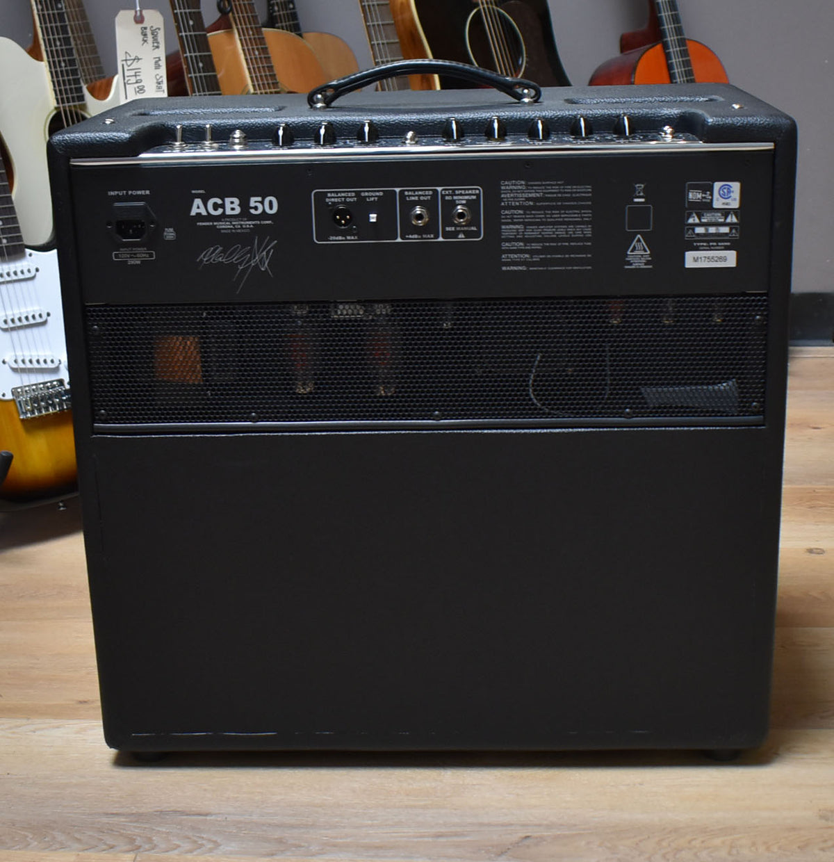 The black combo amp is seen from the rear, showing its input power, balanced, line out, and external speaker jacks.