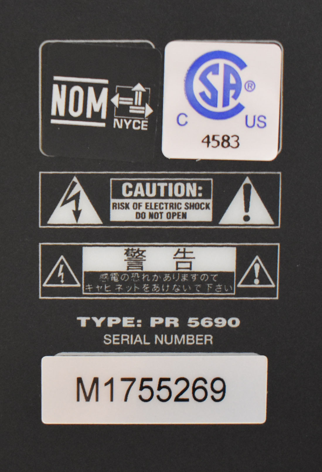 A close-up of the amp's black rear panel shows white safety labels and the serial number M1755269 on a white sticker.