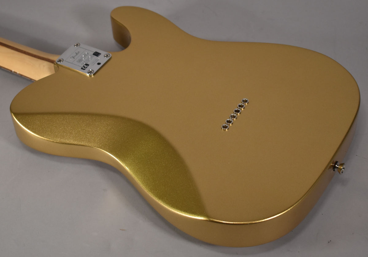 The back of a left-handed Telecaster in metallic gold, showing the neck plate, six string ferrules, and a strap button.